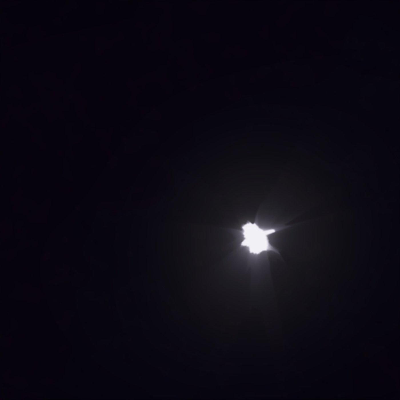 A pitch-black image with a small tear, as if something was thrown through it. Pure white light shines through the tear.