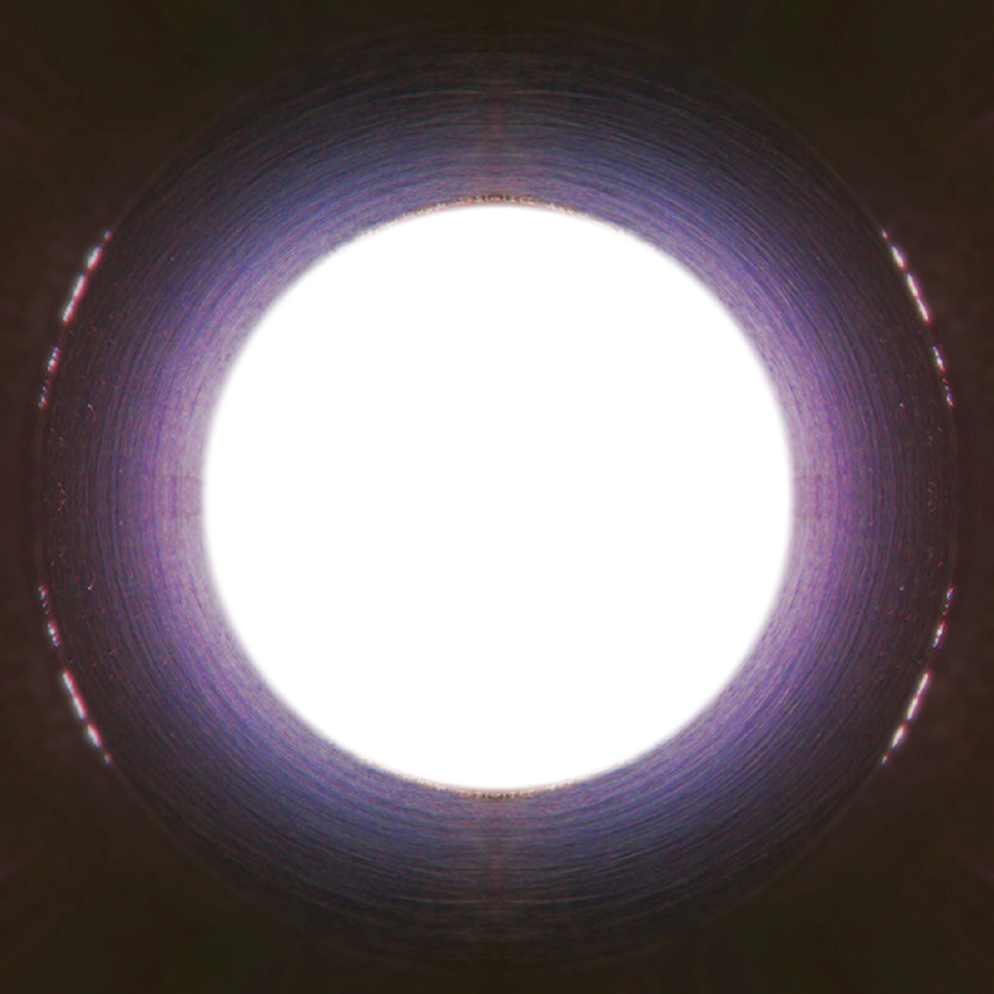 A central hole of white light is surrounded by a tube of darkness.